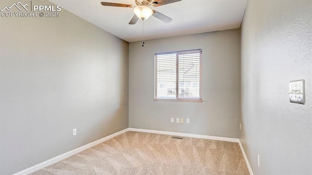 carpeted empty room with visible vents, baseboards, and ceiling fan