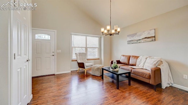 living room featuring visible vents, baseboards, a notable chandelier, wood finished floors, and high vaulted ceiling