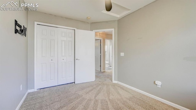 unfurnished bedroom featuring baseboards, carpet flooring, a closet, and ceiling fan