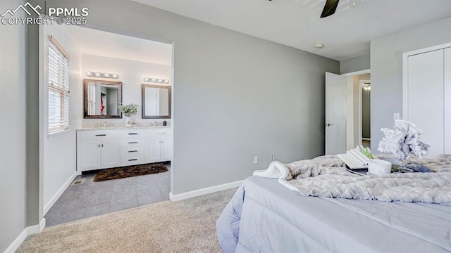 carpeted bedroom with connected bathroom, ceiling fan, baseboards, and a sink