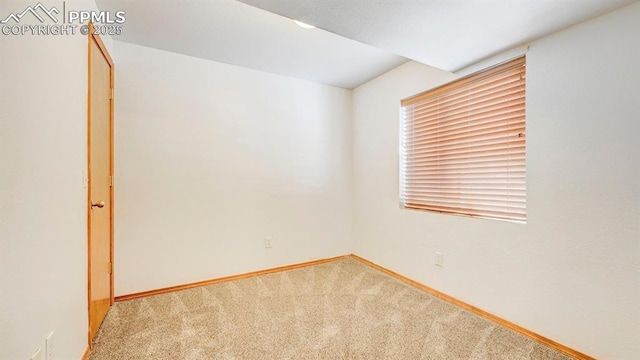 unfurnished room featuring carpet and baseboards