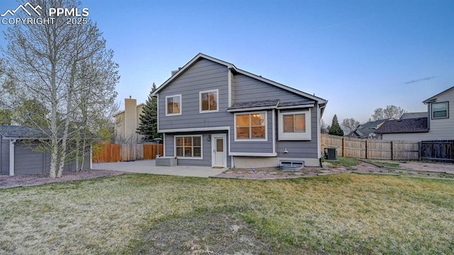back of property with a patio area, a fenced backyard, a yard, and central air condition unit