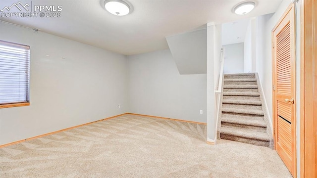 below grade area with baseboards, carpet, and stairs