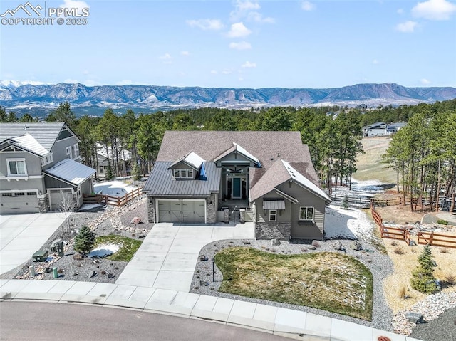 16224 Sunrise Glory Ln, Monument, CO 80132 - view of front of property with concrete driveway, a mountain view, stone siding, a garage, and metal roof
