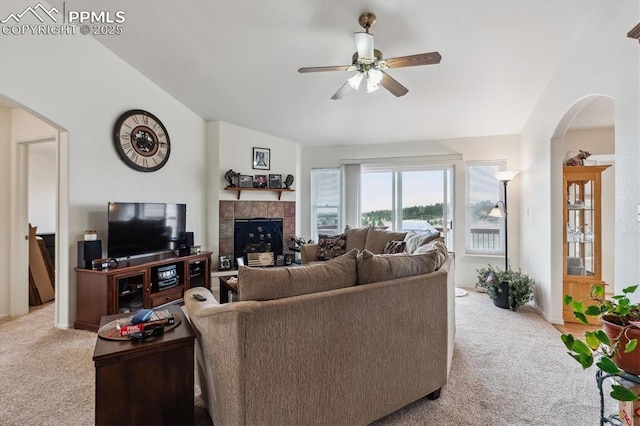13255 Woodlake Rd, Elbert, CO 80106 - carpeted living area with vaulted ceiling, a fireplace, a ceiling fan, and arched walkways