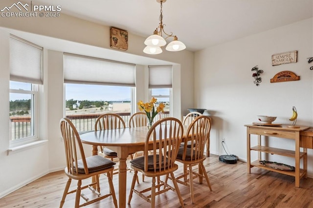 13255 Woodlake Rd, Elbert, CO 80106 - dining area with a chandelier, baseboards, and light wood-style floors