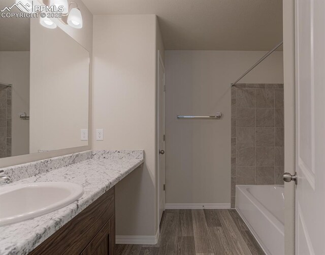 5229 Devers Ct, Colorado Springs, CO 80925 - bathroom featuring baseboards,  shower combination, wood finished floors, and vanity
