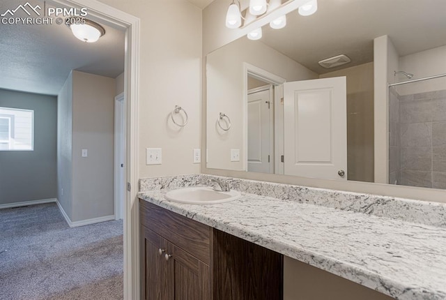 5229 Devers Ct, Colorado Springs, CO 80925 - bathroom with baseboards, walk in shower, and vanity