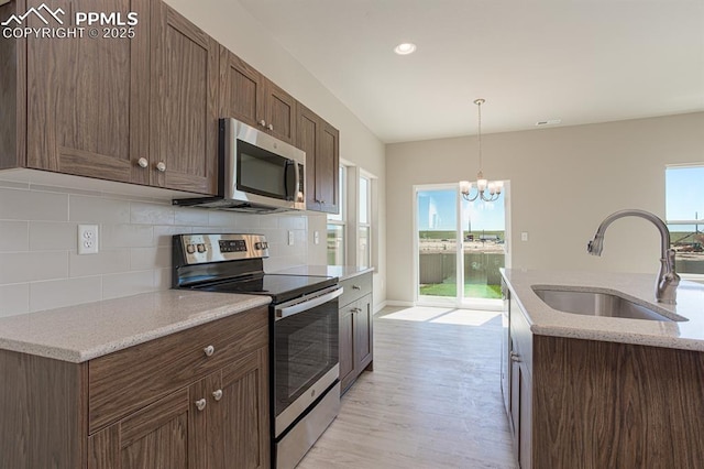 5229 Devers Ct, Colorado Springs, CO 80925 - kitchen with an inviting chandelier, stainless steel appliances, backsplash, hanging light fixtures, and a sink