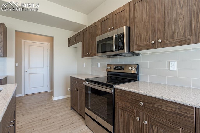 5229 Devers Ct, Colorado Springs, CO 80925 - kitchen with backsplash, stainless steel appliances, baseboards, and light wood finished floors