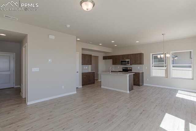 5229 Devers Ct, Colorado Springs, CO 80925 - kitchen featuring a notable chandelier, light countertops, appliances with stainless steel finishes, open floor plan, and light wood-type flooring