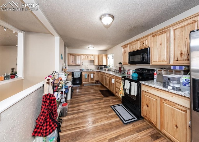 2914 Del Mar Cir, Colorado Springs, CO 80910 - kitchen with black appliances, light brown cabinetry, wood finished floors, a textured ceiling, and light countertops