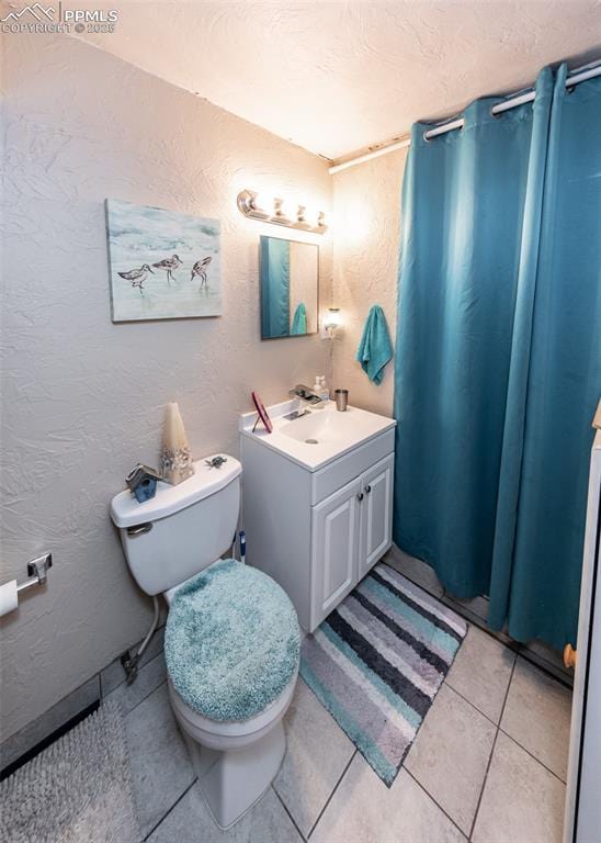 2914 Del Mar Cir, Colorado Springs, CO 80910 - bathroom with toilet, vanity, tile patterned flooring, and a textured wall
