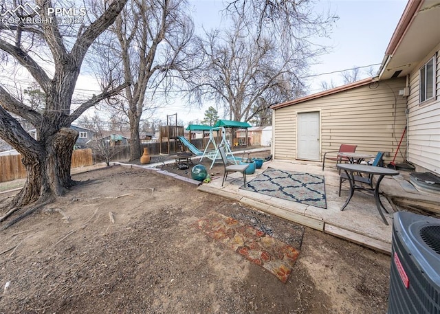 2914 Del Mar Cir, Colorado Springs, CO 80910 - view of patio / terrace featuring a playground, central AC, and a fenced backyard
