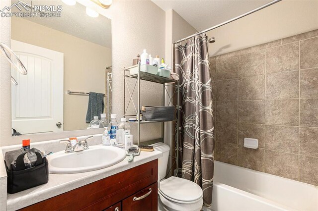 bathroom with shower / bathtub combination with curtain, toilet, and vanity