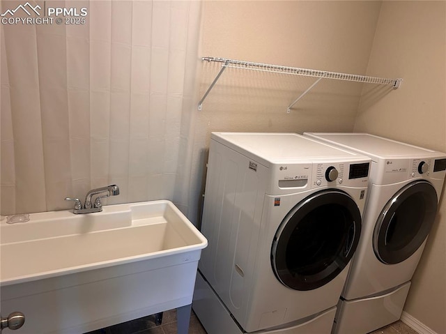 washroom with washer and dryer, laundry area, and a sink
