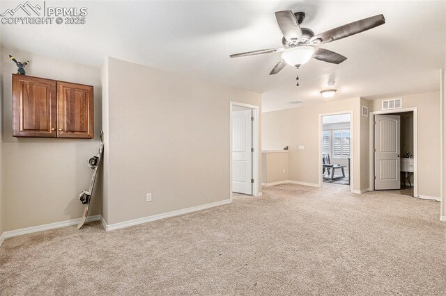 unfurnished bedroom featuring baseboards, visible vents, a ceiling fan, and light colored carpet
