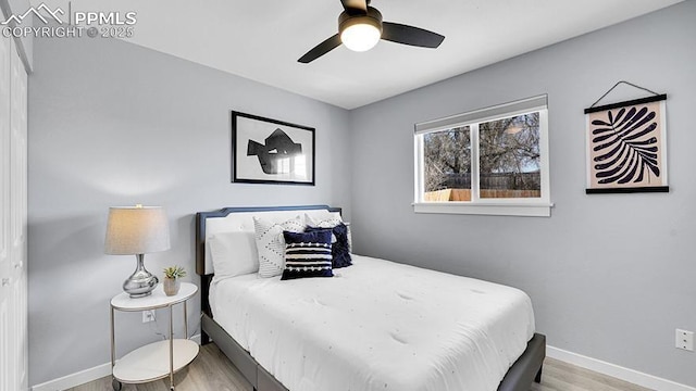bedroom featuring baseboards, ceiling fan, and wood finished floors