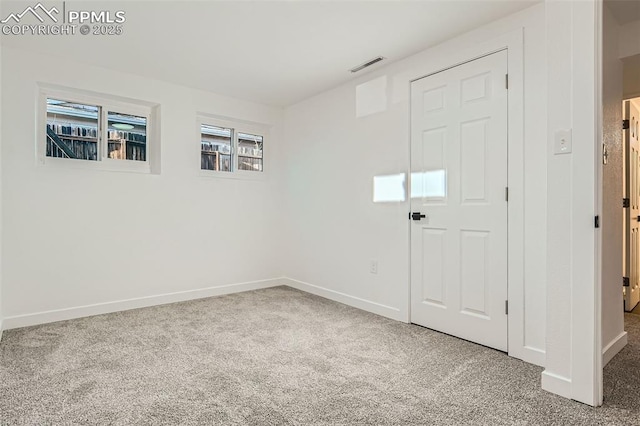 unfurnished room with baseboards, visible vents, and carpet floors