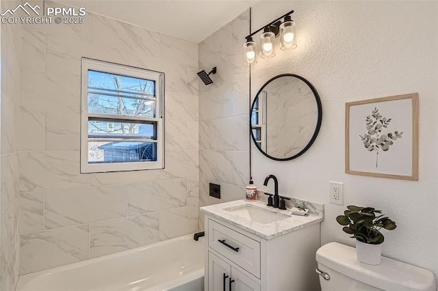 bathroom featuring a textured wall, tub / shower combination, toilet, and vanity