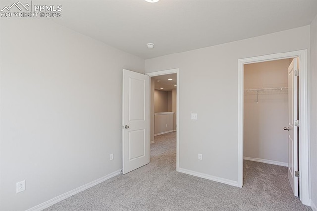7372 Cornice Pt, Colorado Springs, CO 80923 - unfurnished bedroom with light carpet, baseboards, a closet, and a walk in closet