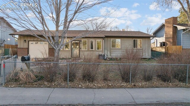 6745 Fielding Cir, Colorado Springs, CO 80911 - ranch-style house with a fenced front yard, an attached garage, and brick siding