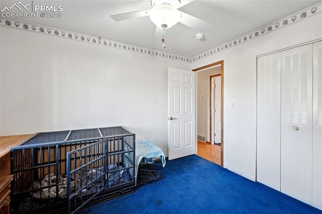 6745 Fielding Cir, Colorado Springs, CO 80911 - carpeted bedroom with a closet, a textured ceiling, visible vents, and a ceiling fan