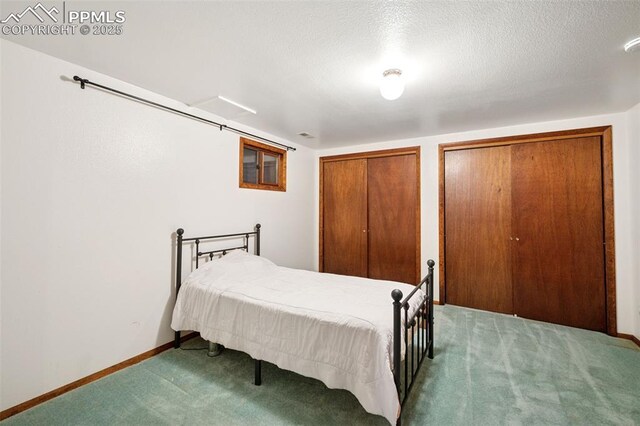 6745 Fielding Cir, Colorado Springs, CO 80911 - bedroom featuring baseboards, two closets, carpet floors, and a textured ceiling