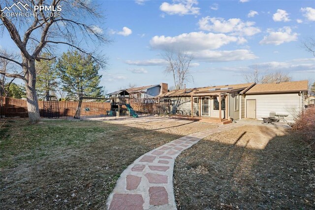6745 Fielding Cir, Colorado Springs, CO 80911 - view of yard featuring a patio, fence, and a playground