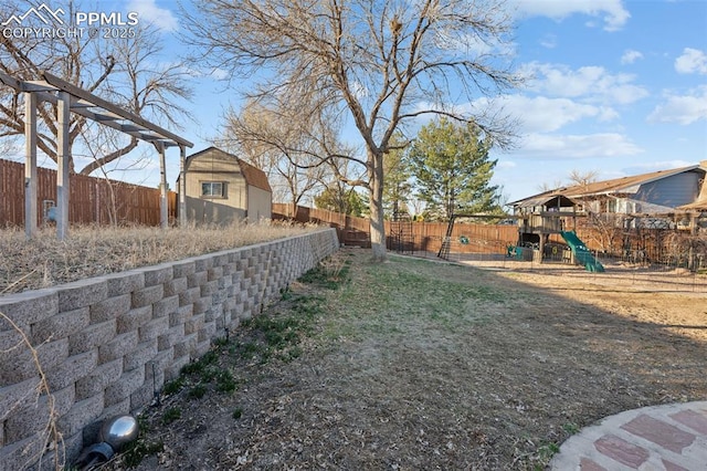 6745 Fielding Cir, Colorado Springs, CO 80911 - view of yard featuring a fenced backyard, a playground, an outbuilding, and a shed