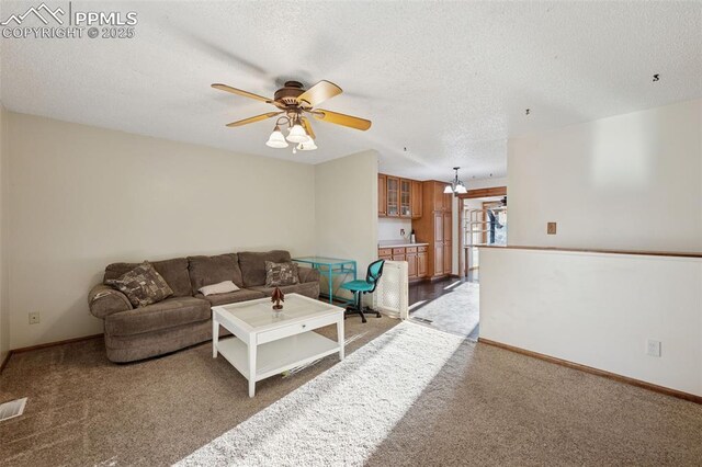 6745 Fielding Cir, Colorado Springs, CO 80911 - living area with a ceiling fan, light carpet, baseboards, and a textured ceiling