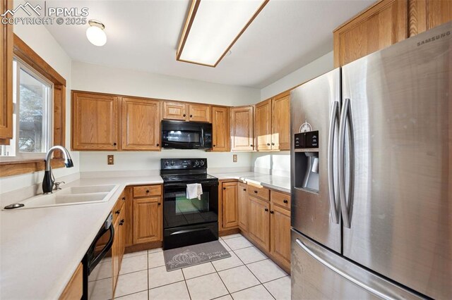 6745 Fielding Cir, Colorado Springs, CO 80911 - kitchen with light countertops, brown cabinets, a sink, black appliances, and light tile patterned floors
