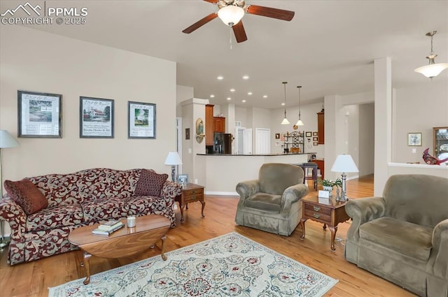 living room with baseboards, ceiling fan, recessed lighting, and light wood-type flooring