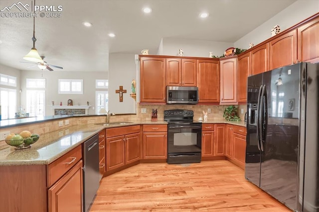 kitchen featuring a sink, light stone countertops, tasteful backsplash, black appliances, and ceiling fan
