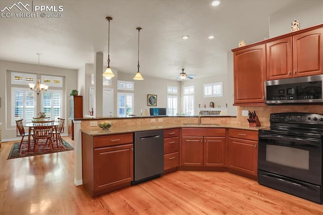 kitchen with black electric range oven, stainless steel microwave, a sink, dishwashing machine, and a peninsula
