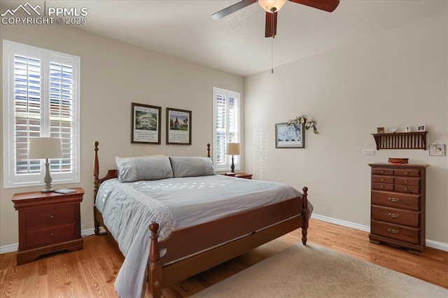 bedroom featuring light wood finished floors, baseboards, and a ceiling fan