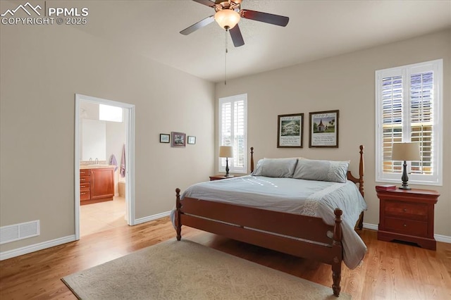 bedroom featuring light wood-style flooring, baseboards, ensuite bath, visible vents, and a ceiling fan
