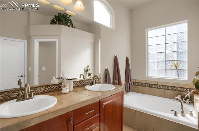 full bathroom with double vanity, a sink, and a garden tub