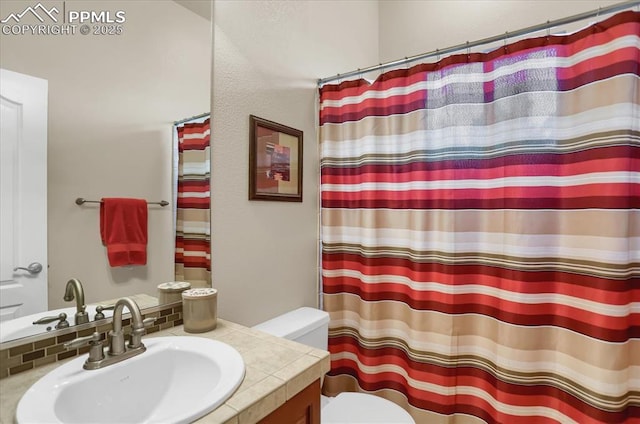 bathroom with toilet, vanity, and curtained shower