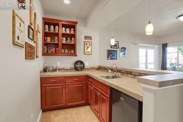 kitchen with dishwashing machine, decorative light fixtures, a sink, and a peninsula