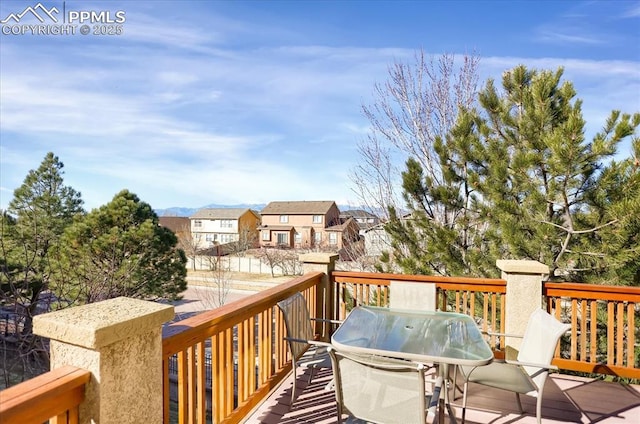wooden deck featuring outdoor dining space and a residential view