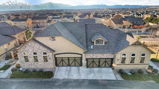 view of front facade with stucco siding, an attached garage, a residential view, and driveway