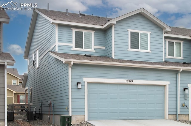 exterior space with a garage, concrete driveway, central AC unit, and fence