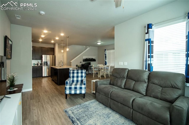 living area featuring baseboards, visible vents, and wood finished floors