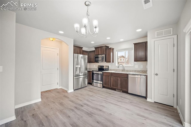 7718 Benecia Dr, Fountain, CO 80817 - kitchen featuring arched walkways, dark brown cabinets, visible vents, appliances with stainless steel finishes, and a sink