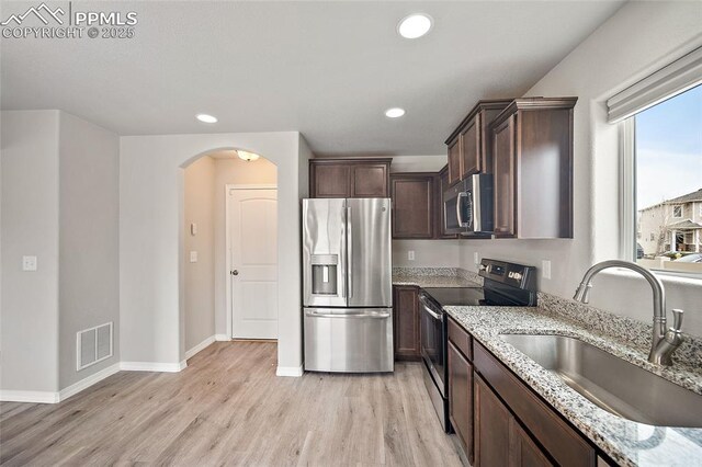7718 Benecia Dr, Fountain, CO 80817 - kitchen with light stone counters, visible vents, appliances with stainless steel finishes, arched walkways, and a sink