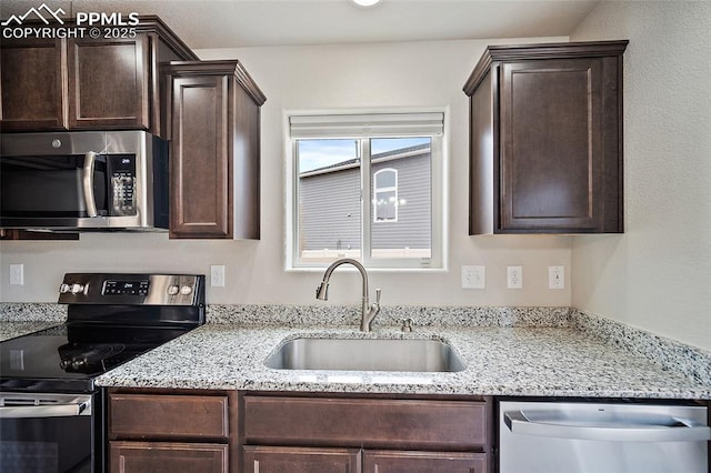 7718 Benecia Dr, Fountain, CO 80817 - kitchen featuring light stone countertops, dark brown cabinetry, a sink, and appliances with stainless steel finishes