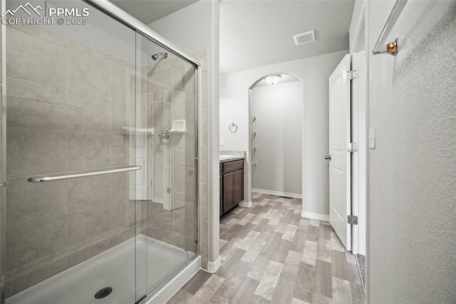 7718 Benecia Dr, Fountain, CO 80817 - bathroom with visible vents, baseboards, vanity, wood finished floors, and a stall shower