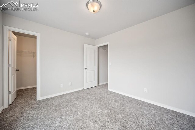 7718 Benecia Dr, Fountain, CO 80817 - unfurnished bedroom with a closet, baseboards, a walk in closet, and carpet