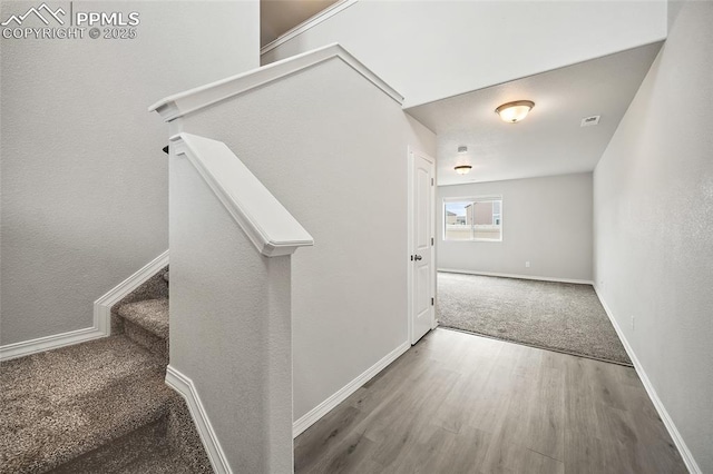 7718 Benecia Dr, Fountain, CO 80817 - interior space featuring visible vents, baseboards, wood finished floors, and stairs